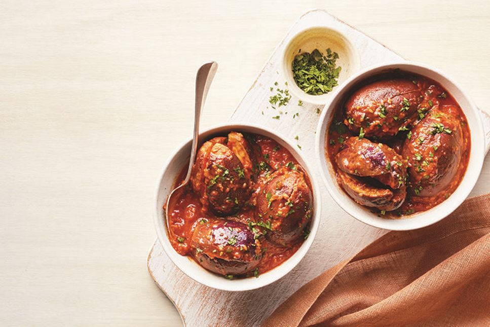 Two bowls of eggplant in peanut sauce